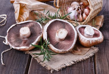 Portobello mushrooms over rustic wooden background clipart