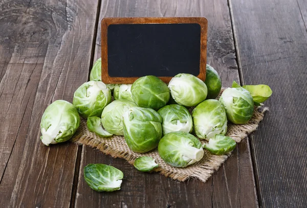 Brussels sprouts over rustic wooden background — Stock Photo, Image