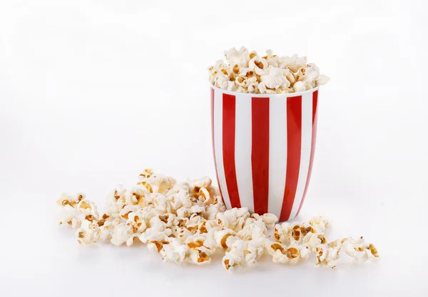 Palomitas con mantequilla en un tazón a rayas sobre fondo blanco —  Fotos de Stock