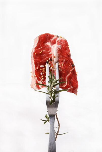 A piece of red meat on a fork