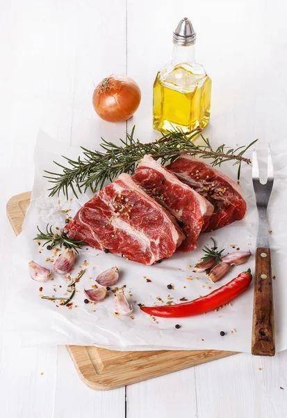 Rött kött och kryddor över vit bakgrund — Stockfoto