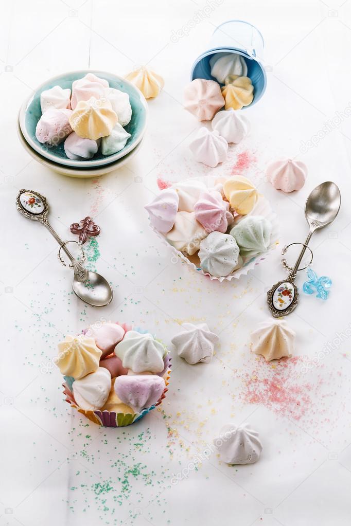 Colorful meringue cookies over white wooden background