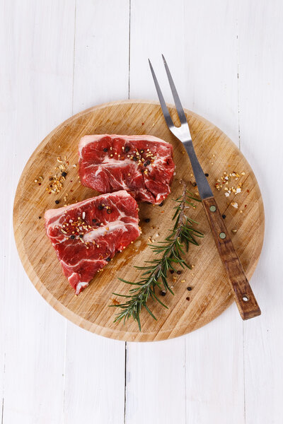 Red meat and rosemary over white background