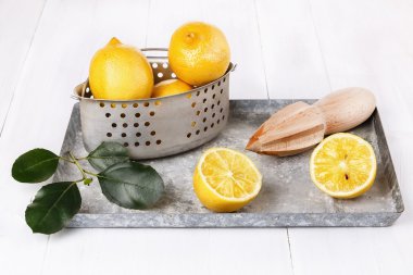 Beyaz ahşap zemin üzerinde vintage kevgir içinde organik limon 