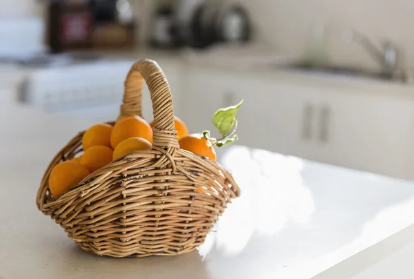 Cocina mesa y cesta de naranjas —  Fotos de Stock