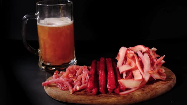 Bier Ergießt Sich Einen Becher Hinter Fleischsnacks Isoliert Auf Schwarzem — Stockvideo