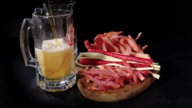 Bira siyah arka planda izole edilmiş abur cuburların arkasına dökülür. İki bira bardağı. Yavaş çekim 120 fp. Yüksek kaliteli FullHD görüntüler