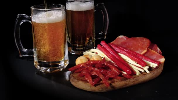 Cerveza Vierte Una Taza Detrás Bocadillos Aislados Sobre Fondo Negro — Vídeo de stock