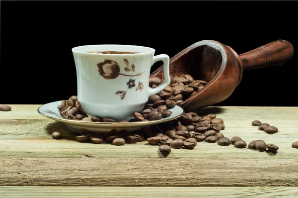 En kopp kaffe och trä sked isolerade på svart — Stockfoto