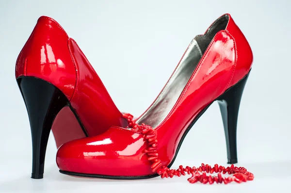 Zapatos rojos y collar en blanco —  Fotos de Stock