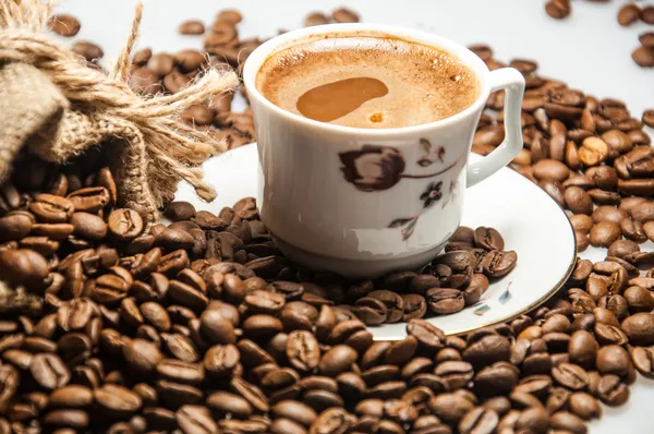En kopp kaffe och kaffebönor — Stockfoto