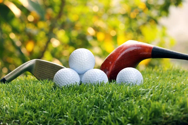 Golfbollar och drivrutiner på grönt gräs — Stockfoto