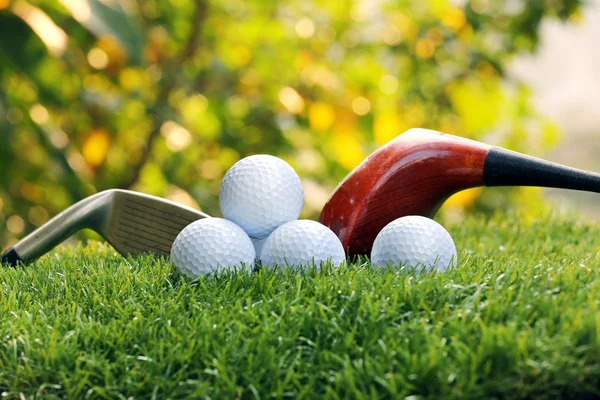 Pelotas de golf y conductores en hierba verde Imágenes de stock libres de derechos