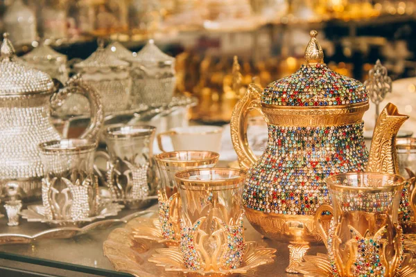Tradiční turecké čajové sklenice podávané v obchodě se suvenýry. Čajová souprava s čajovou konvicí zdobená mnohobarevnými krystaly. Oblíbený suvenýr a dárek z Turecka. Selektivní zaměření — Stock fotografie