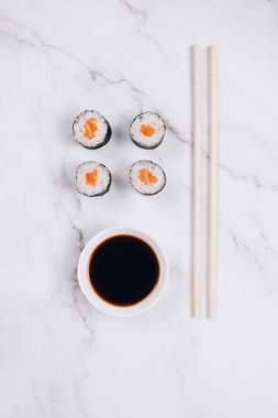 Klasik somon ya da ton balıklı sashimi, soya sosu ve yemek çubukları mermer masa arkasında - maki sushi roll, nori maki, futomaki. Asya yemeği teslimatı, online sipariş yiyecek konsepti veya suşi bar menüsü