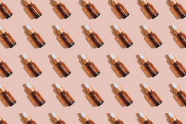 Temel yağlı cam damlalardan yapılmış desen, hyaluronik asit ya da pastel bej arka planda serumdan. Model görüntüsü. Modern organik kozmetik, yüz yaşlanmayı önleyici yağ. Seçici odak