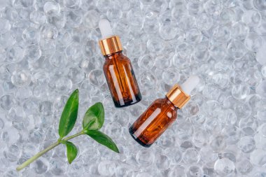 Jel baloncukları üzerinde kolajen ve peptid içeren anti-yaşlanma serumuyla dolu şişeler. Fotokopi alanı olan. Kozmetik sıvı kolajen ya da gerekli yağ. Cilt bakımı konsepti. Resmi düzenle