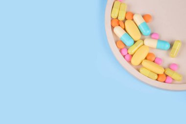 Bağışıklık sistemi vitaminleri ve takviyeleri. Beslenme biyo takviyeleri. Çok renkli ilaç hapları, kapsüller ve tabletler mavi arka planda metnin için kopya alanı ile birlikte..