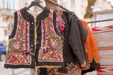 Lviv, Ukraine - January 8, 2022 : Ukrainian traditional clothes - traditional embroidered sleeveless jacket. Secondhand goods on flea market, thrift shopping concept. Selective focus. Vernisazh market