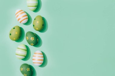 Easter eggs on pastel mint background with copy space for text. Easter greeting card concept. Flat lay. Selective focus