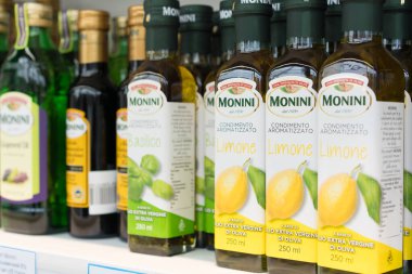 Lviv, Ukrayna - 20 Şubat 2022: Süpermarkette ekstra saf İtalyan zeytinyağı içeren çeşitli şişeler, limon ve fesleğen aromalı zeytinyağı, Akdeniz baharatları