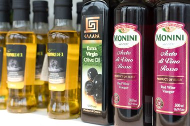 Lviv, Ukrayna - 20 Şubat 2022: İtalyan markası Monini kırmızı şarap sirkesi, Yunan ekstra bakire zeytinyağı Ellada, İspanyol markası Priordei süpermarkette, Akdeniz baharatlarında