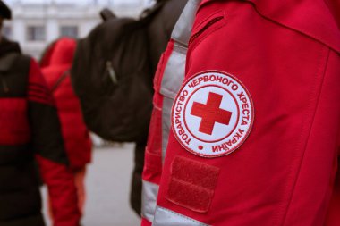 Lviv, Ukrayna - 8 Mart 2022: Kızılhaç görevi Ukrayna 'daki çatışma sırasında mültecilere yardım etmek - Ukrayna amblemi. Seçici odak