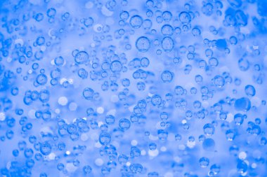 Mavi şeffaf kozmetik jel dokusu ya da arka planda kabarcık ve kopyalama alanı olan yüz serumu. Banyo kozmetik jel arka planı. Seçici odak