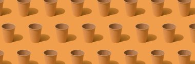 Banner, turuncu arka planda eko-kağıt kahve fincanı deseni, model görüntüsü. Sürdürülebilir gıda paketleme kavramı