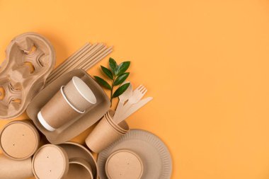 Kraft kağıt mutfak aletleri, kağıt kaplar ve bardaklar, fotokopi alanı olan turuncu arka planda pipet içmek. Sokak yiyecekleri ambalaj konsepti. Üst görünüm