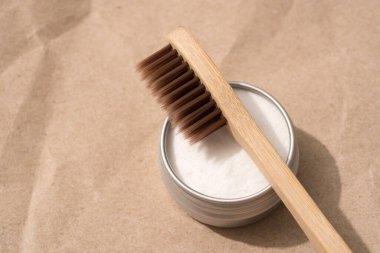 Kahverengi ahşap bambu diş fırçaları ve mineral diş tozu kaolini, Kraft kağıdının arka planında metal kabın içinde. Doğal banyo ürünleri, organik diş fırçası. Üst görünüm