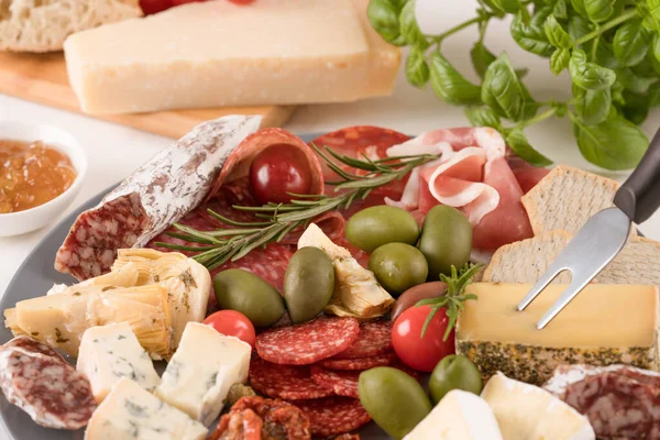 Peynir çeşitleri, kurutulmuş sosisler, kurutulmuş domates, zeytin, reçel ve otlarla servis edilen beyaz masa - parmesan, dorblu, prosciutto, salam. Peynir ve meze tabağı. Geleneksel İtalyan mezeleri