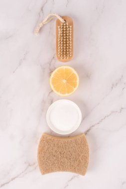 Doğal temizlik malzemeleri olan dikey görüntü. Bambu fırçası, limon, kabartma tozu, mermer zemin üzerinde sitrik asit. Yeşil temizlik konsepti, seçici odaklanma. Düz yatıyordu
