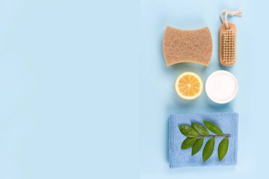 Doğal ev temizleyicileri - kabartma tozu, limon, sitrik asit, bambu fırçası, mavi arka planda fotokopi alanı olan doğal sünger. Yeşil ev kavramı. Biyolojik organik temizleyiciler ve ev yapımı çamaşır suyu.