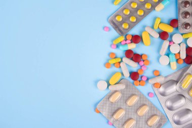 Mavi arka plandaki kabarcıklarda ilaç, kapsül ve tablet çeşitleri ve metin için fotokopi alanı. Bağışıklık sistemi vitaminleri ve takviyeleri. Beslenme biyo takviyeleri. Seçici odak