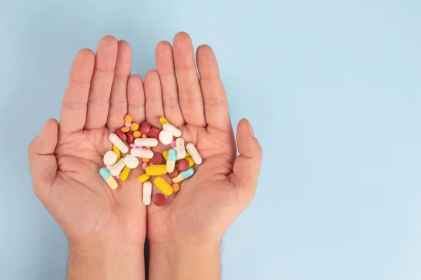 Elinde Çeşitli Ilaç Hapları Kapsüller Tabletler Tutan Adam Mavi Arka — Stok fotoğraf