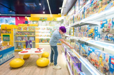 Lviv, Ukrayna - 7 Mayıs 2022: En büyük oyuncakçı Budynok igrashok (Toy 's House) iç mekanı. Ergen çocuk oyuncak pazarında doğum günü hediyesini seçiyor. Seçici odak