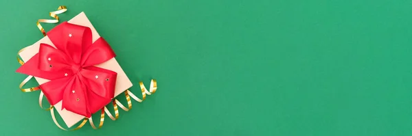 お祭りのクリスマスバナーの背景 コピースペースと緑の背景に赤いリボン弓と黄金の装飾リボンと現在のボックス 誕生日プレゼントボックス — ストック写真