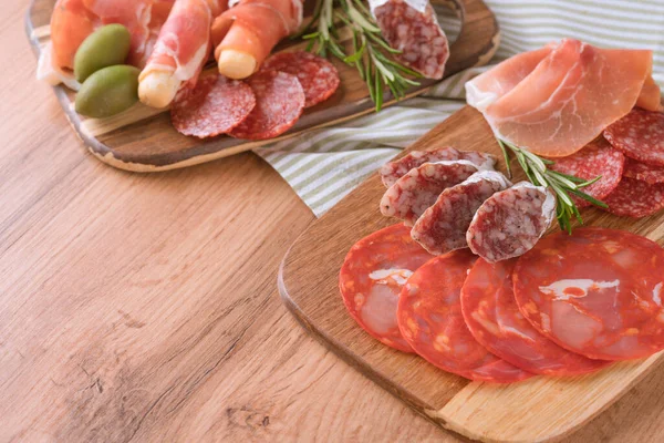 Çeşitli mezeler, çeşitli sosislerle servis edilen şarküteri kurulu salam, bresaola, zeytinli proscuitto. Tahta servis tahtaları ve geleneksel İtalyan antipastası ile ahşap masa zemininde fotokopi alanı.