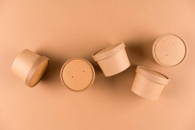 Çorba ya da dondurma için Eko Kraft kağıt yiyecek kabı, fotokopi alanı ile açık kahverengi arka planı olan kağıt kapaklı bardak, taklit görüntü. Sürdürülebilir gıda paketleme kavramı
