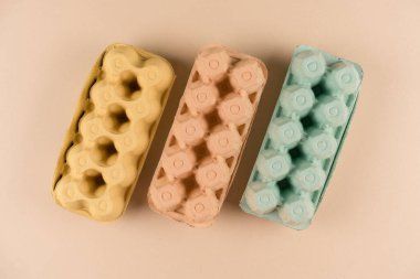 Açık kahverengi arka planda hamurdan ve samandan yapılmış yumurta kutuları. Çevre dostu yumurta kutuları, sürdürülebilir gıda paketleme konsepti. Düz yat, model al.