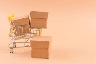 Açık kahverengi arkaplanda depolama veya taşınma için karton kutularla dolu alışveriş tepsisi sunumunuz veya web siteniz için fotokopi alanı. Sürdürülebilir ambalaj kavramı