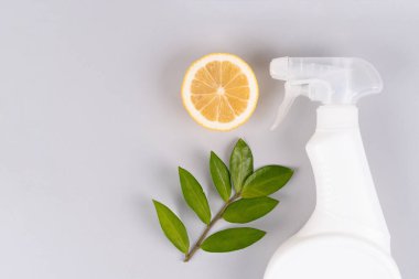 Doğal ev yapımı ev yapımı temizleyicili beyaz sprey şişesi ya da açık gri arka planda fotokopi alanı olan limonla yapılmış oda spreyi. Biyo organik deterjan ürünleri, ev temizliği konsepti. Yeşil ev