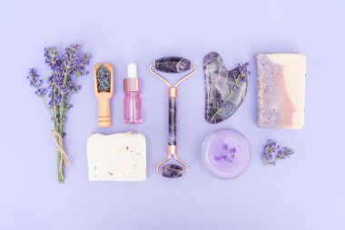 Kişisel bakım ürünleri için doğal aksesuarlar. Mora boyanmış vücut ve cilt bakımı, lavanta çiçekleri. Lavanta özlü doğal bitkisel kozmetik ürünleri, evde güzellik tedavileri. Düzleştirme biçimi