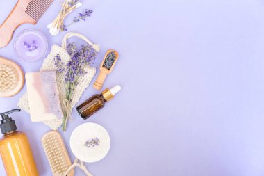Vücut ve cilt bakımı için doğal banyo aksesuarları ve özbakım ürünleri. Mor arka planda, metin için kopyalama alanı ile birlikte. Doğal lavanta kozmetik seti, ekolojik yaşam konsepti. Düzleştirme biçimi