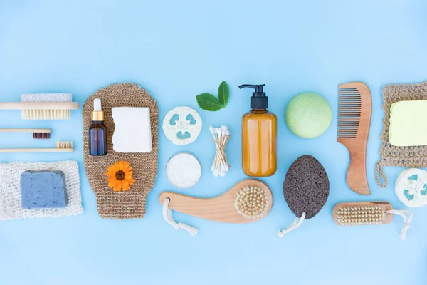 Self-care products bundle and natural bath accessories set for body and skin care at home over blue background. Mockup image. Zero waste and eco living concept. Flat lay style. Home spa