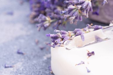 Arka planda fotokopi alanı olan lavanta çiçeklerine karşı lavanta esanslı doğal el yapımı sabun çubuğu. Bitkisel kozmetik ürünleri, lavanta rengi güzellik ürünleri.