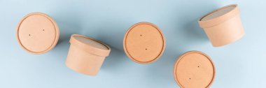 Eco paper food containers - takeaway soup or ice cream containers. Banner with paper cups over light blue background, mockup image. Sustainable food packaging concept