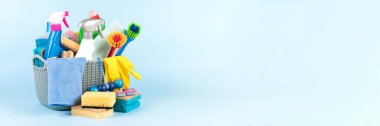 Farklı temizlik malzemeleriyle mavi arka planda fotokopi alanı var. Temizlik hizmeti konsepti. Deterjan ve ev kimyasallarıyla dolu sprey şişeleri. Pankart