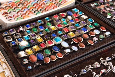 Bit pazarındaki antika ve eski moda yüzükler ya da araba bagajı satışı. Satılık antika eşyalar. Garaj satışı konsepti. Taklit mücevherler, yarı değerli taş yüzükler. Seçici odak